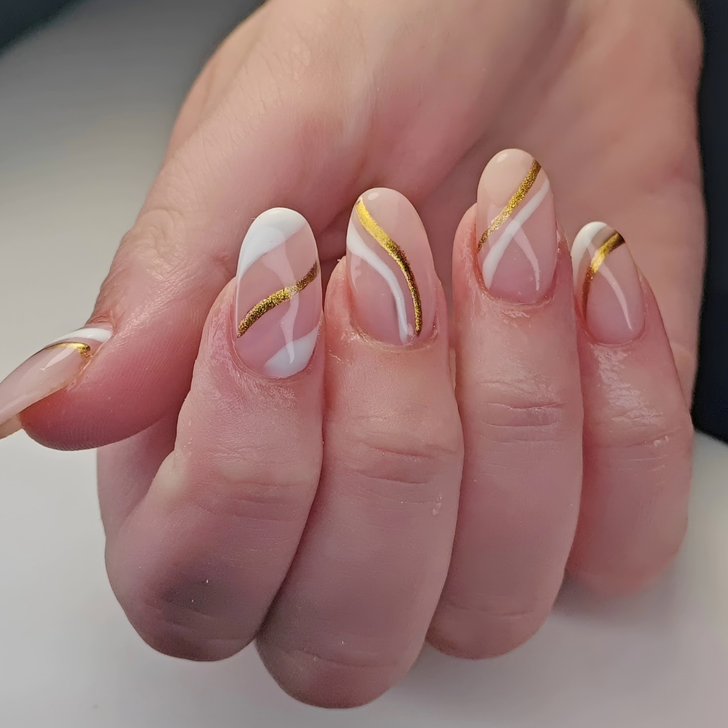 Nude nagels met gouden en witte lijnen